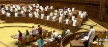Members of the Assembly standing up in homage to ONV Kurup on Monday